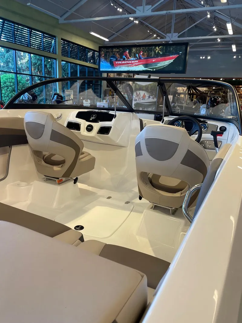 Slide: The Image of 2025 Tahoe 200 S boat interior with modern seating and dashboard in showroom. - 3