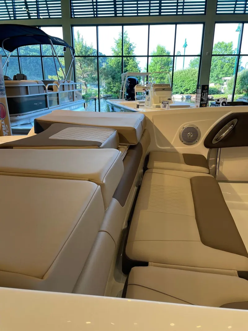 Slide: The Image of 2025 Tahoe 200 S boat interior with beige seating in a showroom. - 4