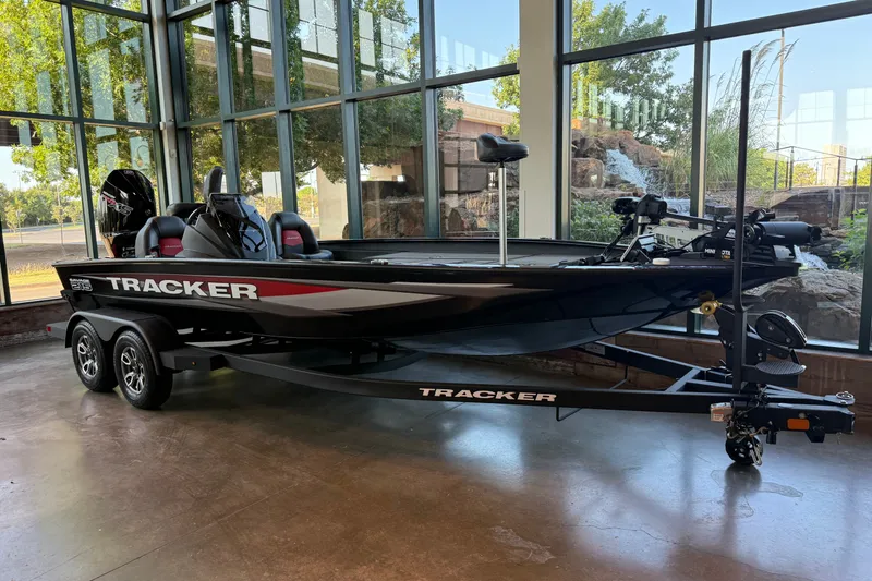 The Image of 2025 Tracker Savage 215 boat displayed indoors with scenic outdoor view. - 0