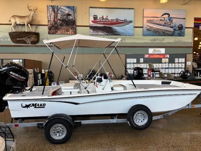 The Image of 2025 Mako Pro Skiff 17 CC boat displayed indoors with canopy and trailer. - 0