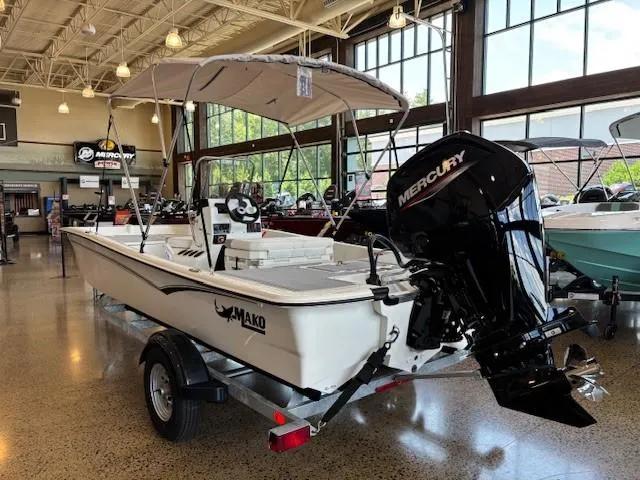 Slide: The Image of 2025 Mako Pro Skiff 17 CC boat with Mercury engine in showroom. - 2