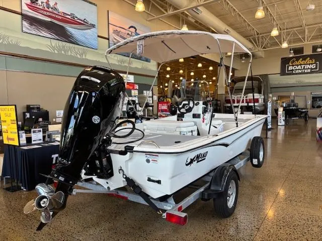 Slide: The Image of 2025 Mako Pro Skiff 17 CC boat displayed indoors at Cabela's Boating Center. - 3
