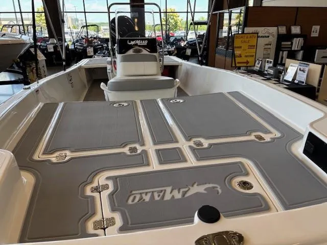 Slide: The Image of 2025 Mako Pro Skiff 17 CC boat interior with gray deck, displayed in showroom. - 7