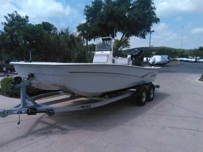 Slide: The Image of 2025 Mako Pro Skiff 19 CC boat on trailer, parked outdoors. - 2