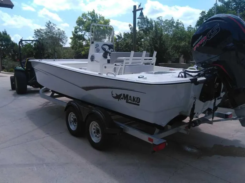 Slide: The Image of 2025 Mako Pro Skiff 19 CC boat on trailer, outdoors, with outboard motor. - 3