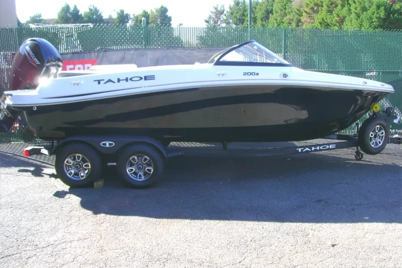 The Image of 2025 Tahoe 200 S boat on trailer, black and white design, parked outdoors. - 0