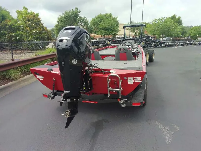 Slide: The Image of 2025 Ranger RT178C boat with outboard motor, parked on pavement, surrounded by greenery. - 2
