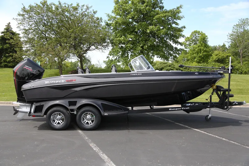 Slide: The Image of 2025 Ranger 2080MS boat on trailer, parked outdoors with trees in background. - 1