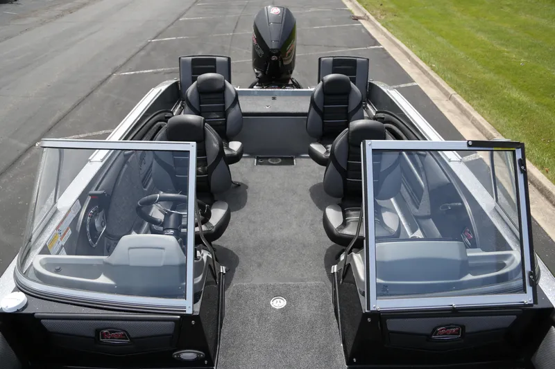 Slide: The Image of 2025 Ranger 2080MS boat interior with seating and windshield, parked on pavement. - 3