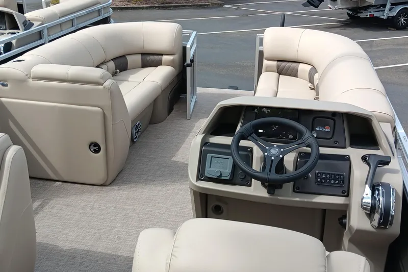 Slide: The Image of 2025 Sun Tracker Party Barge 20 DLX interior with beige seating and steering console. - 4