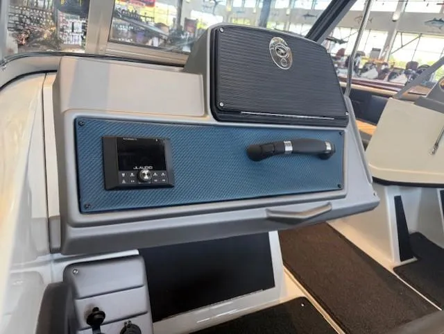 Slide: The Image of 2025 Ranger 1850MS boat dashboard with audio controls and storage compartment. - 12