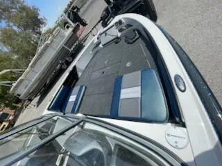 Slide: The Image of 2025 Ranger 1850MS boat interior with blue and gray seating, docked outdoors. - 14