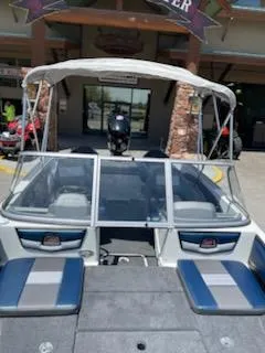 Slide: The Image of 2025 Ranger 1850MS boat with blue and gray seating, docked at a marina. - 15