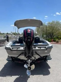 Slide: The Image of 2025 Ranger 1850MS boat with canopy, rear view, parked outdoors under clear sky. - 2