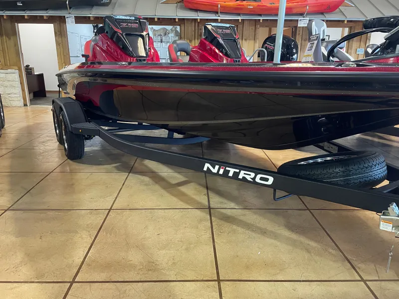 Slide: The Image of 2025 Nitro Z19 Pro boat on display in showroom, featuring sleek black and red design. - 5