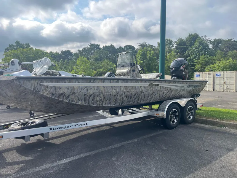 The Image of 2025 Ranger RB200 boat on trailer, camo design, parked outdoors. - 0