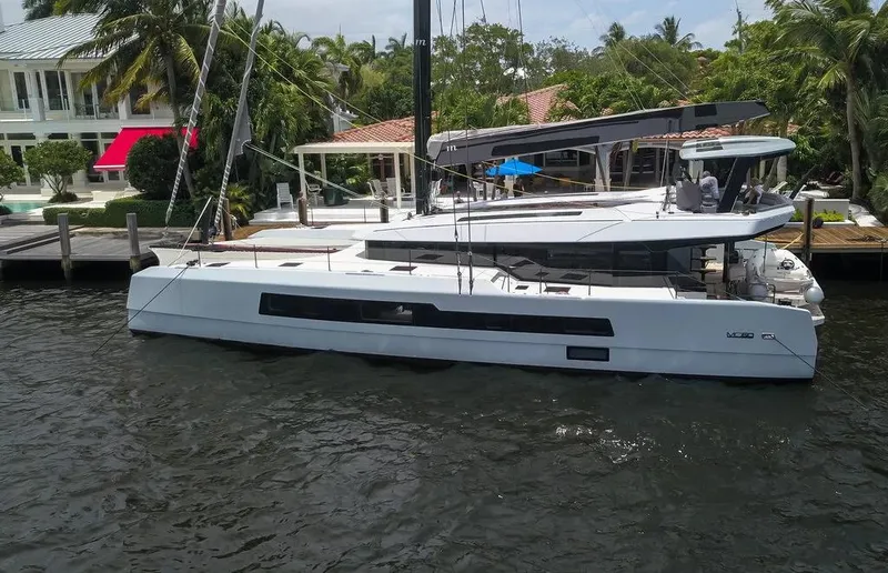 Slide: The Image of 2026 McConaghy MC62 yacht docked by waterfront homes, surrounded by lush greenery. - 5