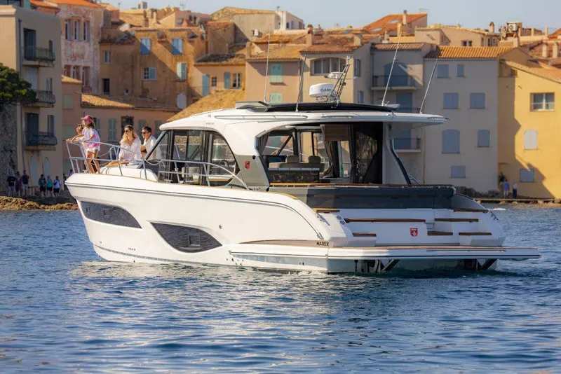Slide: The Image of 2025 Marex 440 Gourmet Cruiser yacht on water near coastal buildings. - 21