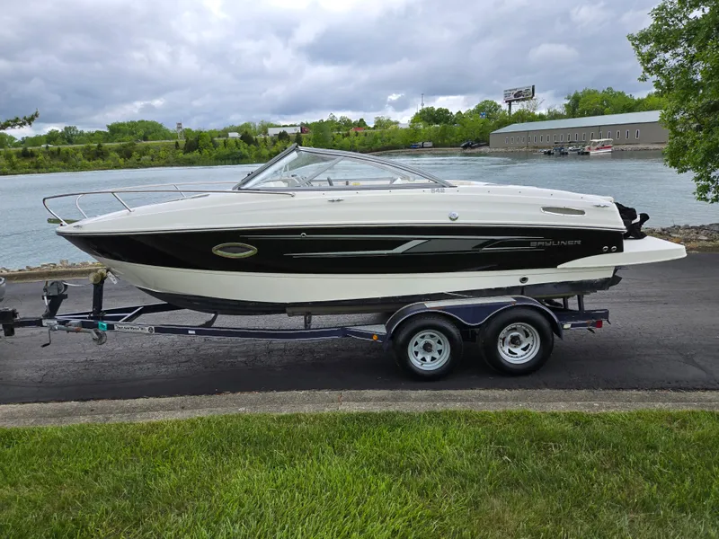 Slide: The Image of 2015 Bayliner 642 Overnighter boat on trailer by a scenic riverside. - 10