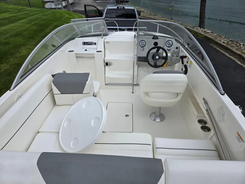 Slide: The Image of 2015 Bayliner 642 Overnighter boat interior with steering wheel, seating, and dashboard. - 11