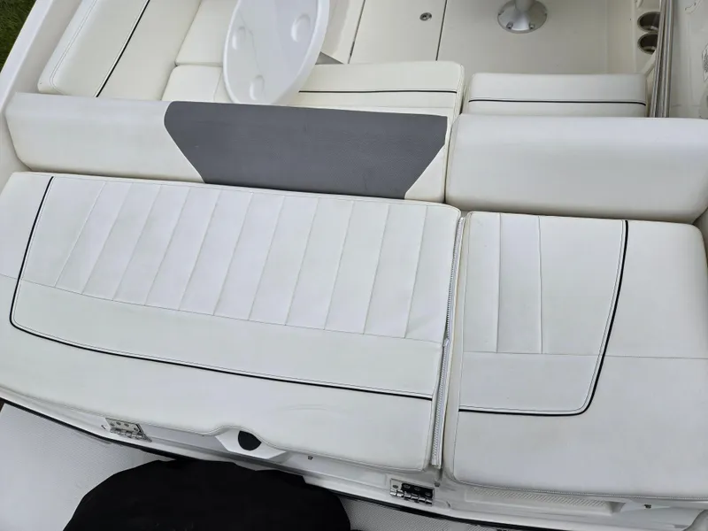 Slide: The Image of 2015 Bayliner 642 Overnighter boat interior with white cushioned seating and table. - 12