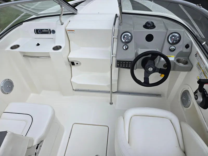 Slide: The Image of 2015 Bayliner 642 Overnighter boat interior with steering wheel and dashboard controls. - 13