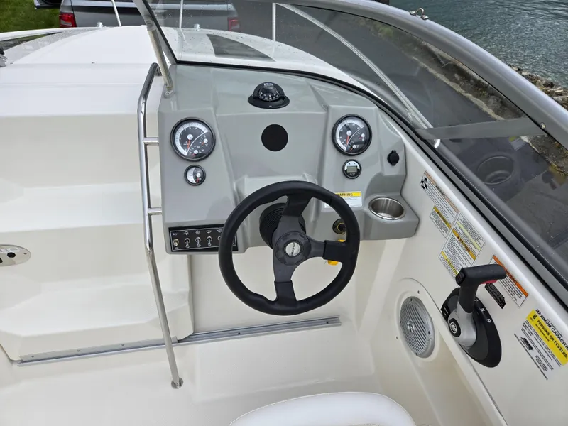 Slide: The Image of 2015 Bayliner 642 Overnighter boat dashboard with steering wheel and control panel. - 14