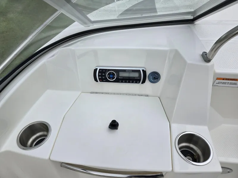 Slide: The Image of 2015 Bayliner 642 Overnighter dashboard with stereo system and cup holders. - 17
