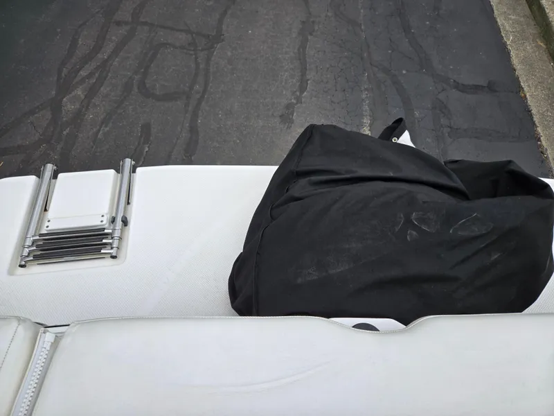 Slide: The Image of 2015 Bayliner 642 Overnighter boat with folded ladder and black cover on white deck. - 27