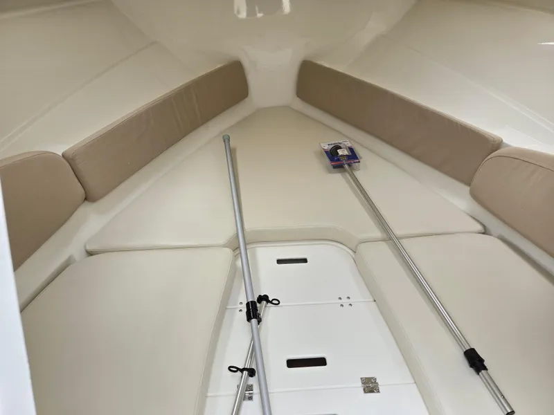 Slide: The Image of Interior of 2015 Bayliner 642 Overnighter boat with beige seating and storage compartments. - 28