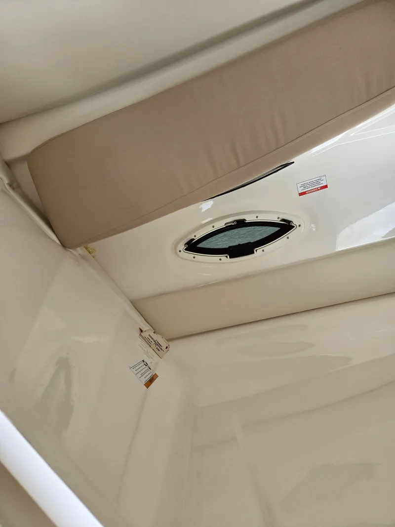 Slide: The Image of 2015 Bayliner 642 Overnighter cabin interior with cushioned seating and porthole. - 31