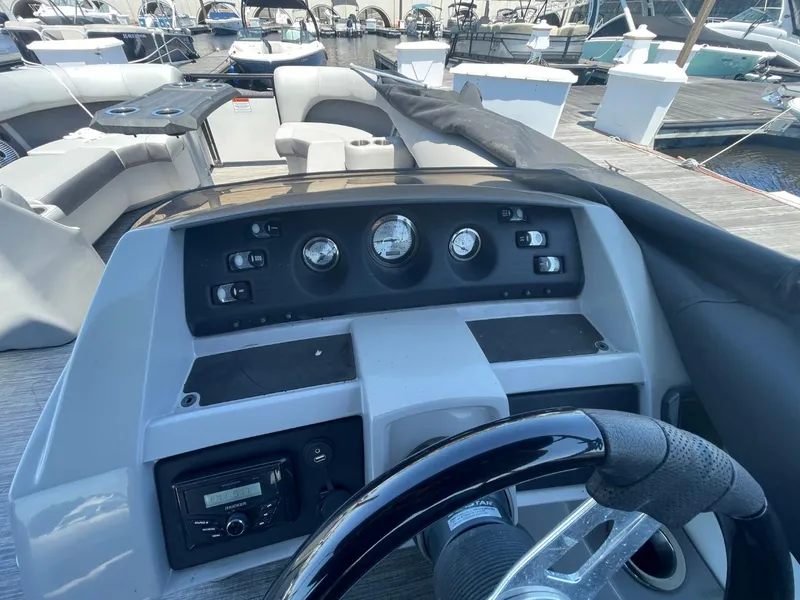 Slide: The Image of 2021 Bennington 24LSR boat dashboard with steering wheel and control panel at marina. - 11