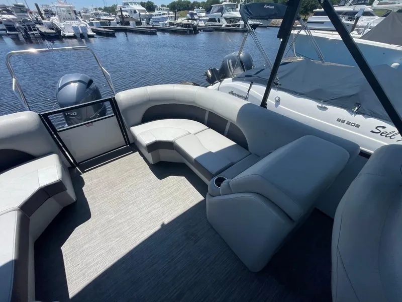 Slide: The Image of 2021 Bennington 24LSR pontoon boat interior with gray seating, docked at marina. - 15