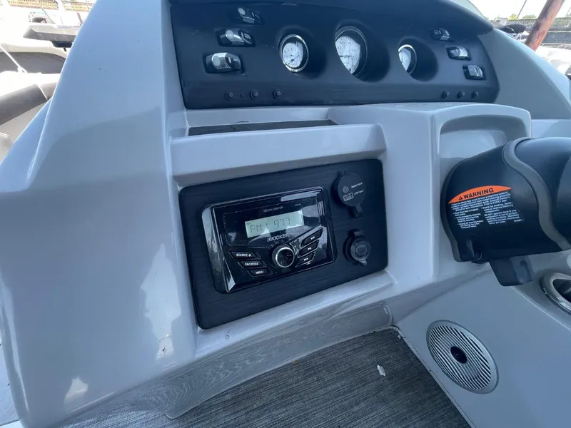 Slide: The Image of Dashboard of a 2021 Bennington 24LSR boat featuring controls and stereo system. - 24
