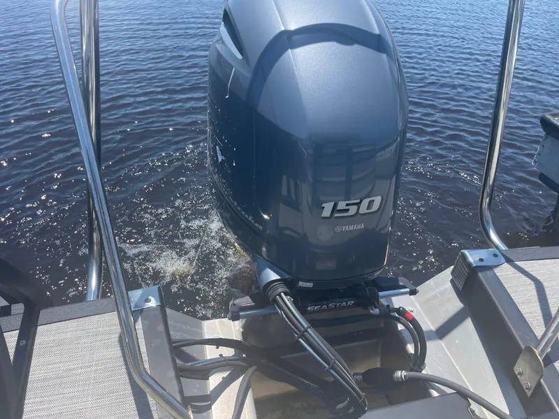 Slide: The Image of 2021 Bennington 24LSR with Yamaha 150 outboard motor on water. - 26