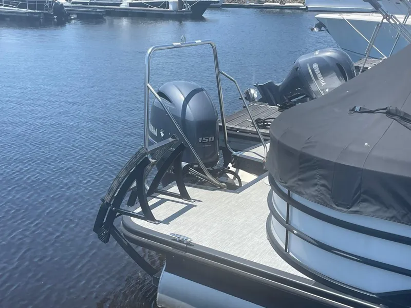 Slide: The Image of 2021 Bennington 24LSR pontoon boat with Yamaha 150 engine, docked on calm water. - 6