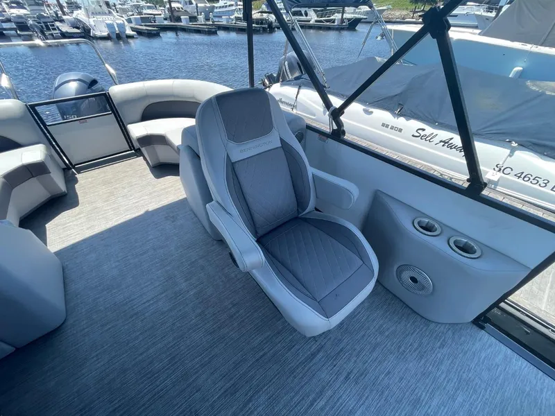 Slide: The Image of 2021 Bennington 24LSR boat interior with gray seating and waterfront view. - 9