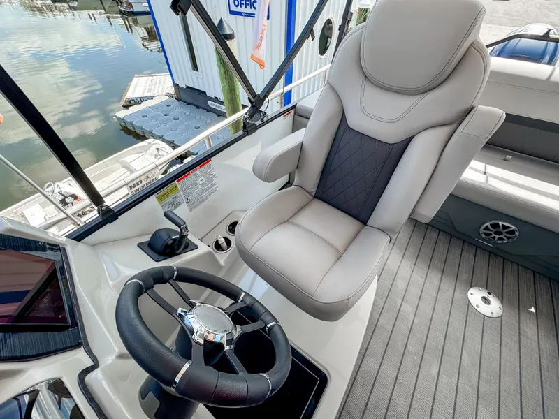 Slide: The Image of 2024 Starcraft CX 23 Q DH boat interior with captain's chair and steering wheel. - 14