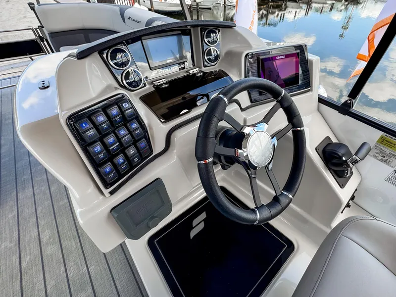 Slide: The Image of 2024 Starcraft CX 23 Q DH boat dashboard with steering wheel and control panels. - 15