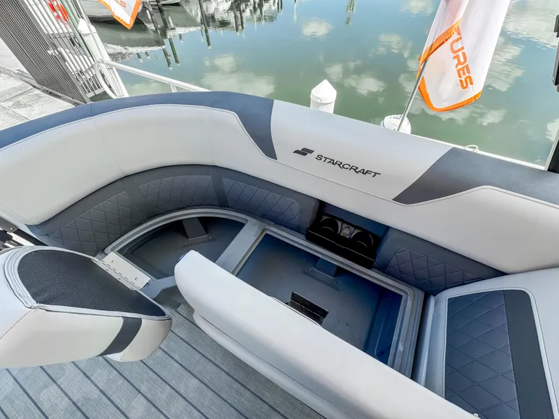 Slide: The Image of 2024 Starcraft CX 23 Q DH boat interior with cushioned seating and storage compartment. - 19