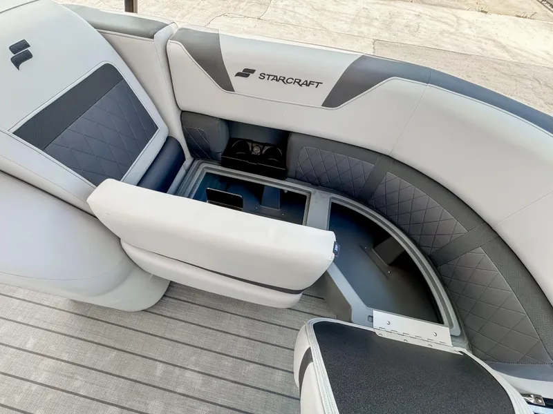 Slide: The Image of 2024 Starcraft CX 23 Q DH boat interior with gray seating and storage compartment. - 21