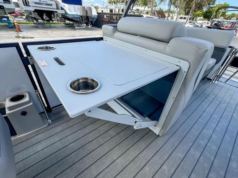 Slide: The Image of 2024 Starcraft CX 23 Q DH boat interior with foldable table and cup holders. - 24