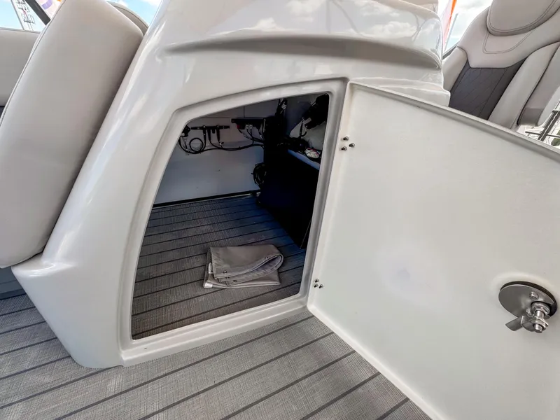 Slide: The Image of 2024 Starcraft CX 23 Q DH boat storage compartment with open door and visible interior. - 25