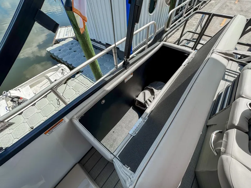 Slide: The Image of 2024 Starcraft CX 23 Q DH boat storage compartment open, showcasing spacious interior. - 27