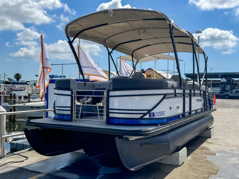 Slide: The Image of 2024 Starcraft CX 23 Q DH pontoon boat docked under sunny skies. - 3