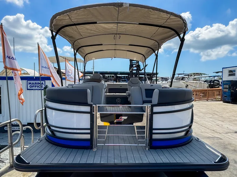 Slide: The Image of 2024 Starcraft CX 23 Q DH pontoon boat with canopy, docked at marina under blue sky. - 4
