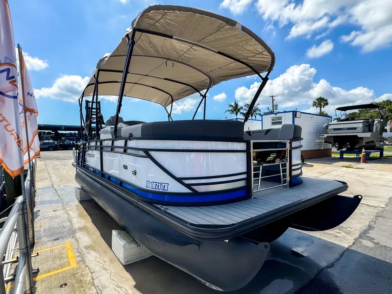 Slide: The Image of 2024 Starcraft CX 23 Q DH pontoon boat with canopy, docked under a sunny sky. - 5