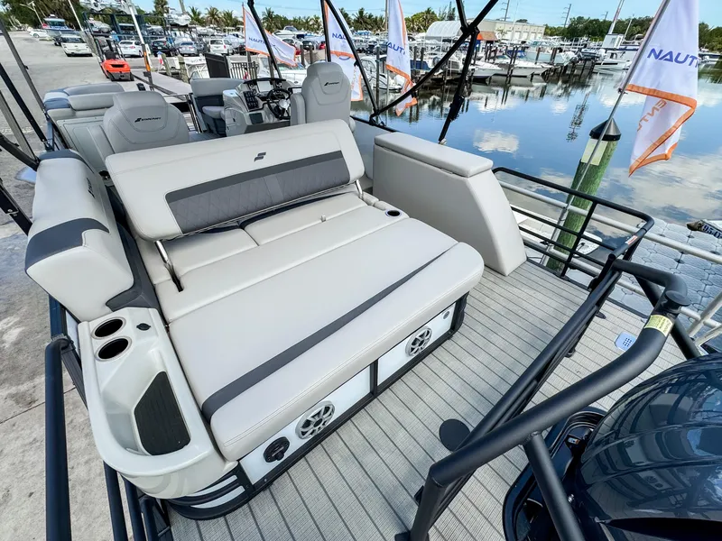 Slide: The Image of 2024 Starcraft CX 23 Q DH pontoon boat with luxurious seating and modern design at a marina. - 7