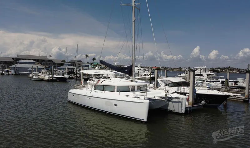 The Image of 2008 Lagoon 420 catamaran docked at a marina under a clear sky. - 0