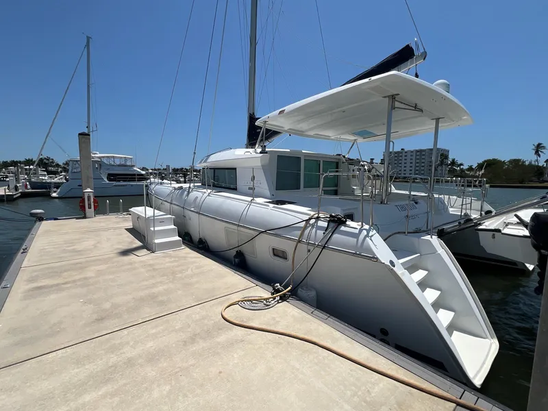 Slide: The Image of 2008 Lagoon 420 catamaran docked at marina under clear blue sky. - 10